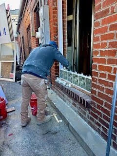 person installing window with glass blocks